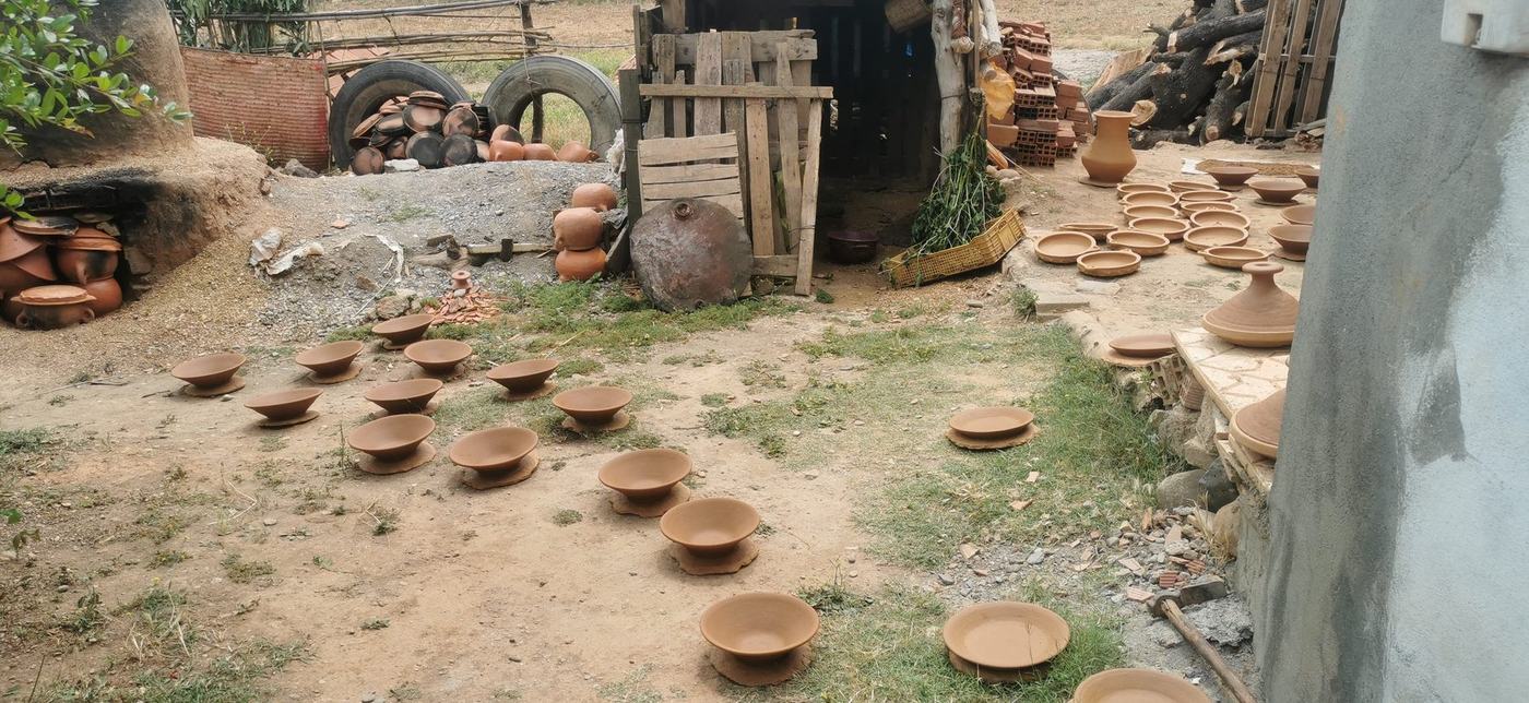 Handmade pottery bowls and plates drying in the yard in Frane Ali